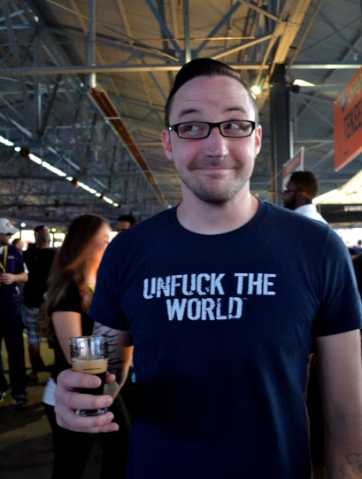 Crafty fellow in a clever shirt enjoying his brew and smirking.