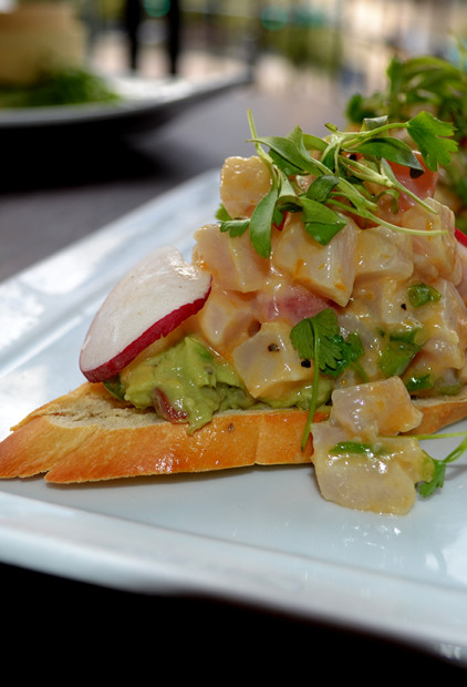 Smooth and luscious, happiness happens when eating the Japaneses Yellow Tail Tartare Bruschetta with avocado, aji amarillo, shaved radish, chili garlic and micro cilantro.